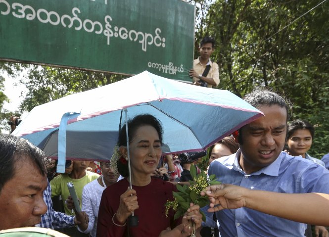 Biểu tượng dân chủ Aung San Suu Kyi nhận hoa từ người ủng hộ khi đến điểm bỏ phiếu ở quê nhà Kawhmu ngày 8-11 - Ảnh: Reuters
