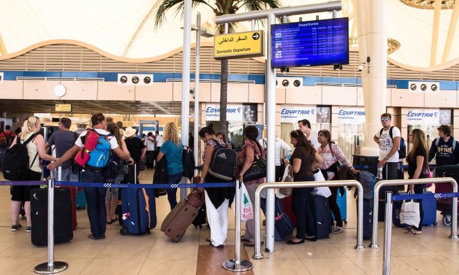 Một nhóm khách du lịch xếp hàng vào cửa soi an ninh tại sân bay Sharm al-Sheikh (AP)