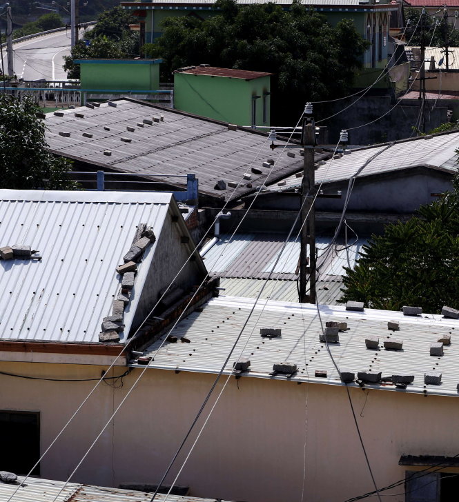 Dây điện 22kV chạy ngang qua mái tôn của các căn nhà ở thôn An Cư Đông 1 - Ảnh: Ngọc Dương