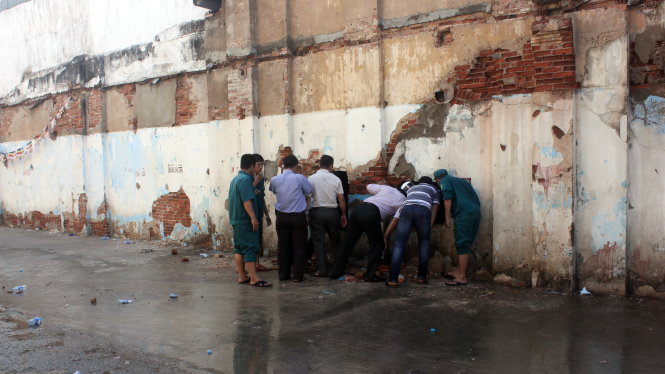 Lực lượng cứu hộ phải đục tường từ phía sau để tiếp cận nạn nhân - Ảnh: Đức Phú