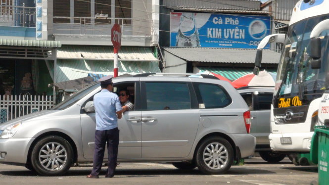 Một nhân viên phà Vàm Cống “hướng dẫn” xe biển trắng xuống phà trước theo làn đường ưu tiên - Ảnh: Đ.Vịnh