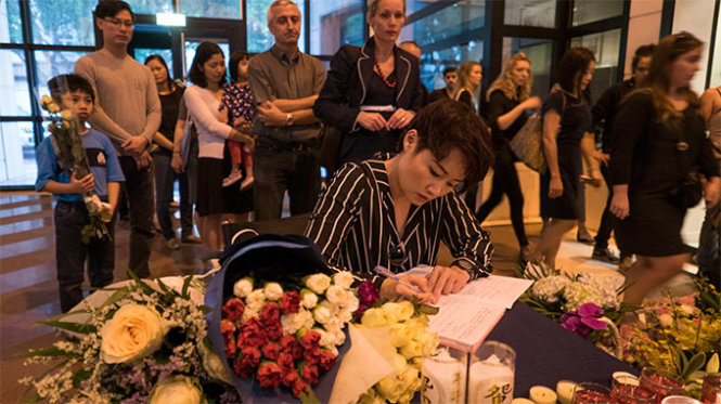 Một vị khách viết những dòng cảm nghĩ tại lễ tưởng niệm các nạn nhân vụ khủng bố ở Paris ở sứ quán Pháp chiều 15-11 - Ảnh: Việt Dũng