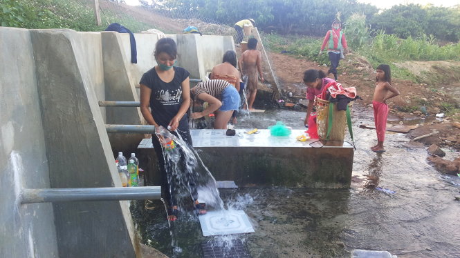 Người dân ra bến nước ở làng Guah (xã Chư Á, TP Pleiku, Gia Lai) để tắm giặt, hứng nước sạch về dùng - Ảnh: Bá Dũng
