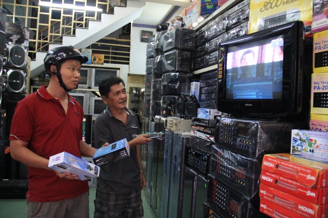 Một hộ dân ở tỉnh Quảng Nam đi mua đầu thu số tại cửa hàng điện máy ở Đà Nẵng - Ảnh: Tr.Trung