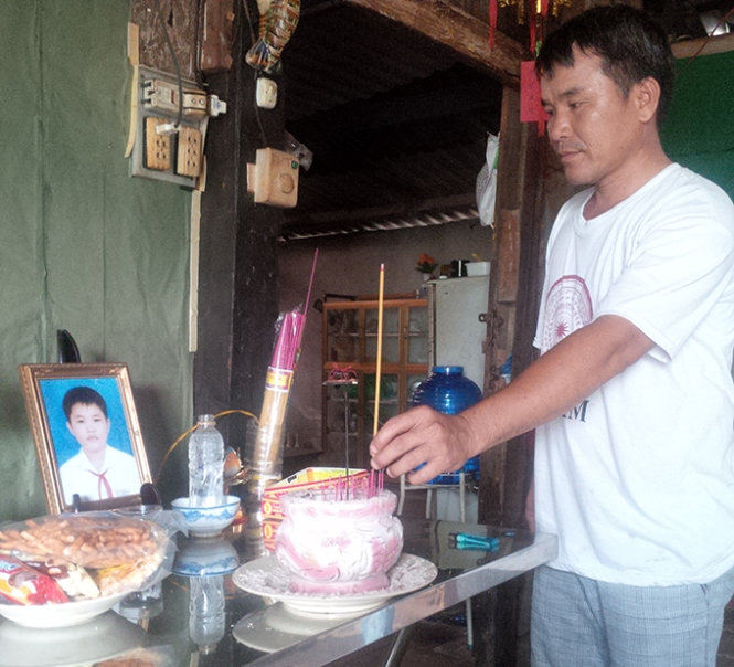 Ông Long, ba của Luân thắp thêm hương cho bàn thờ con - Ảnh: Ái Nhân
