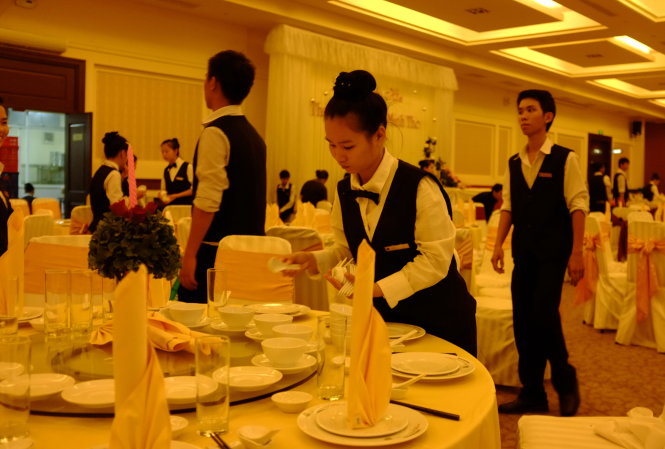 Nhân viên một nhà hàng tổ chức sự kiện cưới trên đường Hồ Văn Huê, quận Phú Nhuận, TP.HCM đang chuẩn bị bàn ăn đón khách - Ảnh: Hoài Linh