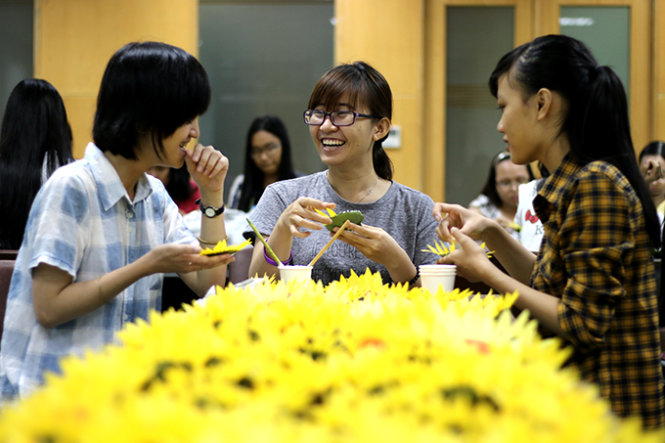 Vào buổi tối, các tình nguyện viên tranh thủ kết hoa gửi đến chương trình Ngày hội hoa hướng dương - Ảnh: Ngọc Hiển