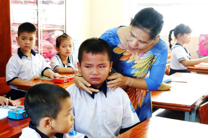 “Thầy cô là cha mẹ của em khi ở trường”. Trong ảnh: cô giáo dỗ dành học sinh lớp 1 trong ngày tựu trường - Ảnh: N.Hùng