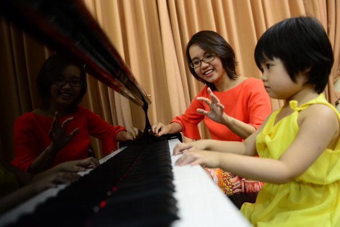 Sa Huỳnh dạy đàn cho con gái, bé Moon, 4 tuổi Ảnh: Quang Định