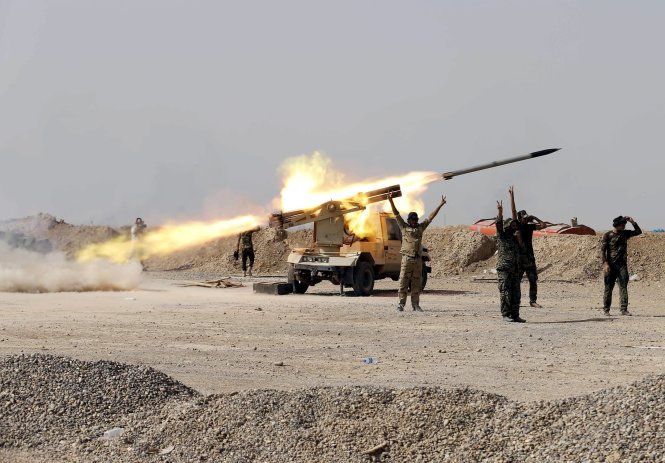 Các chiến binh người Shiite bắn tên lửa về phía IS ở Baija, bắc Baghdad (Iraq) - Ảnh: Reuters