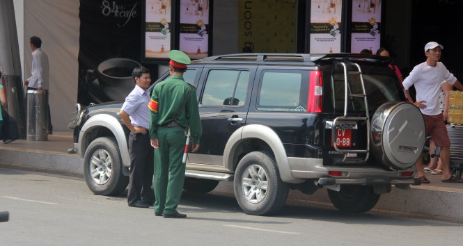 Lực lượng kiểm soát quân sự nhắc nhở một tài xế chạy xe biển đỏ đậu quá thời gian quy định tại khu vực đón khách nhà ga quốc nội Tân Sơn Nhất. Ảnh Q.Khải chụp sáng ngày 24-11 (đề nghị làm mờ biển số).