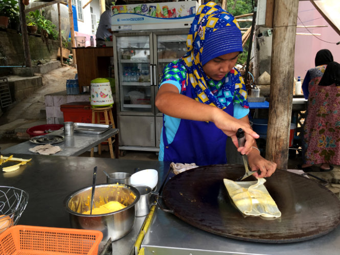 Một phụ nữ đạo Hồi đang làm món bánh Pancake chuối
