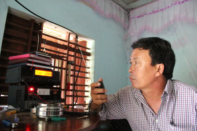 Ông Nguyễn Thanh Nam, người trực icom cộng động xã Bình Châu vẫn đang tiếp tục liên lạc với tàu cá QNg 95861 để theo dõi thông tin tàu đang về đất liền - Ảnh: Trần Mai