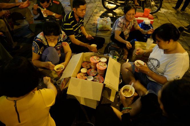 Các gia đình chia nhau tô mì gói từ thiện - Ảnh: Thuận Thắng