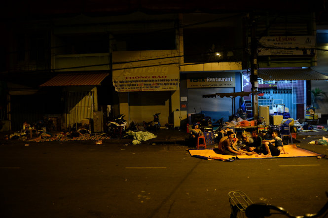 Người dân xóm nghèo khu chợ Gà P.Cầu Ông Lãnh, Q.1 ra ngủ ngoài đường - Ảnh: Thuận Thắng