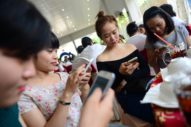 Cùng nhau đi dự tiệc, nhóm các bạn nữ này vẫn tranh thủ sử dụng điện thoại lướt Facebook - Ảnh minh họa: Quang Định
