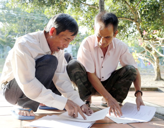 Khi ra tù, ông Huỳnh Văn Nén (phải) bất ngờ với cả ngàn trang giấy tờ, tài liệu pháp lý mà thầy Nguyễn Thận đã lưu giữ trong quá trình kêu oan cho ông - Ảnh: M.Vinh