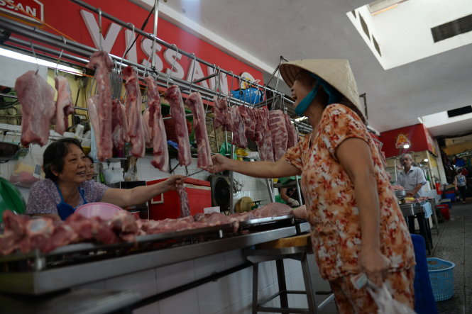 Người dân mua thịt heo tại cửa hàng thịt heo Vissan được bày bán ở chợ Bến Thành, Q.1 sáng 8-12 - Ảnh: Thanh Tùng