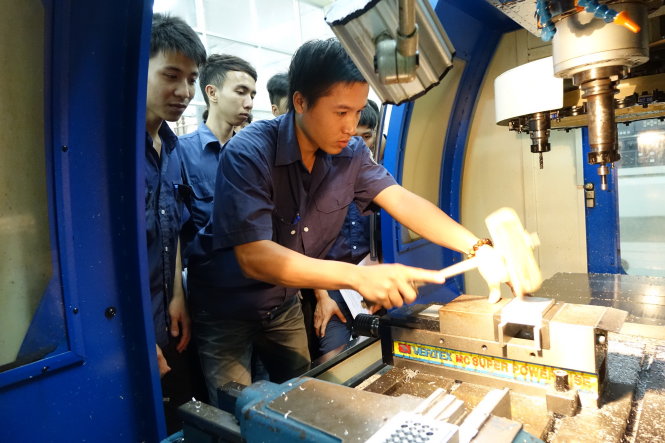 Sinh viên lớp C13CK2 khoa cơ khí chế tạo Trường cao đẳng Nghề TP.HCM trong giờ thực hành tiện trên máy CNC - Ảnh: Như Hùng