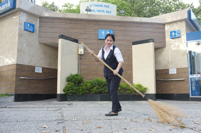 Nhân viên quét dọn làm sạch khu vực nhà vệ sinh công cộng trong công viên 23-9, TP.HCM - Ảnh: Châu Anh