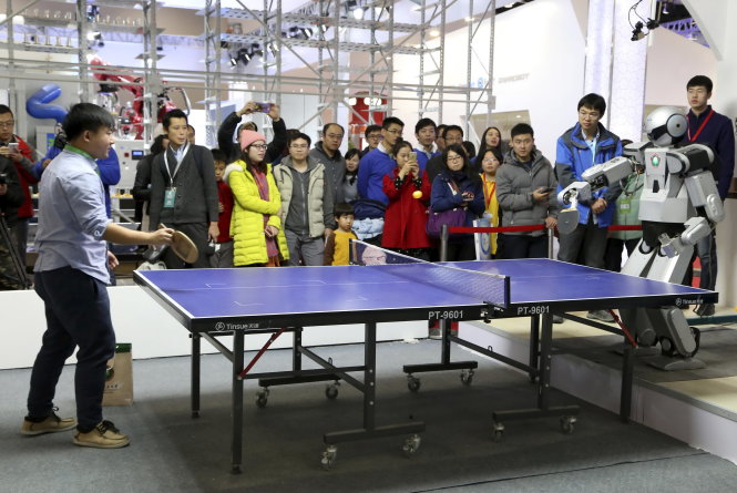 Robot biểu diễn đánh bóng bàn cùng con người tại Hội nghị thế giới về robot ở Bắc Kinh tháng 11-2015 - Ảnh: Reuters