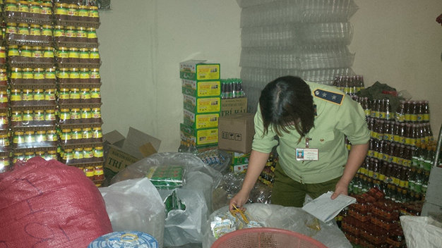 Đội quản lý thị trường số 5 (Đồng Nai) lập biên bản một cơ sở sản xuất hàng thực phẩm tại Trảng Bom, phát hiện 30.000 nhãn mác, chai lọ nhiều mặt hàng gia vị, thực phẩm (tương đậu, rau câu, sa tế, gia vị bò kho...) không rõ nguồn gốc - Ảnh: Đ.Trong