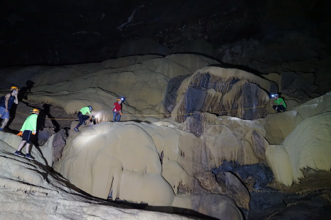 Hồi hộp với màn bám dây để vượt qua một dãy đá trong hang Va - Ảnh: H.TH.