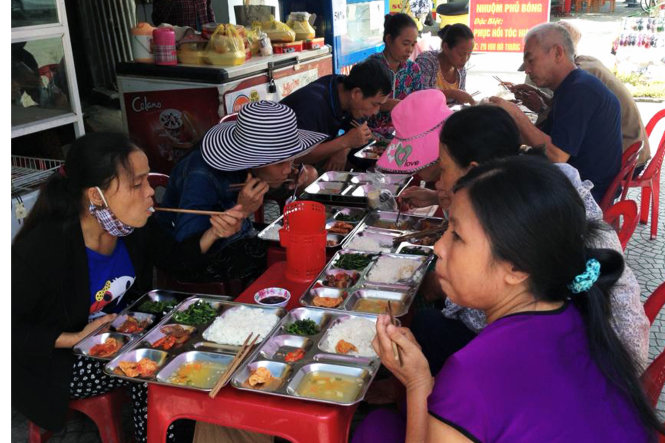 Người lao động nghèo ăn cơm trưa tại quán chị Huệ - Ảnh: H.Mận