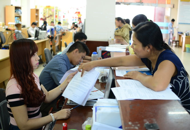 Đại diện doanh nghiệp và người dân làm thủ tục BHXH, BHYT tại BHXH TP.HCM      Ảnh: T.T.D.