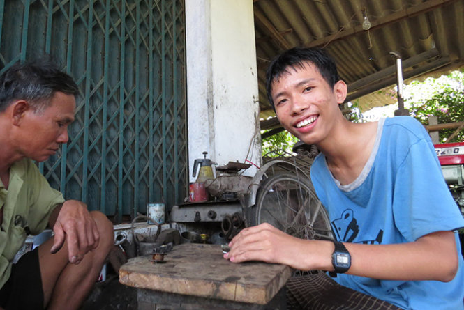 Khoa tranh thủ phụ cha sửa máy nổ trong những ngày cha con được gần nhau - Ảnh: Duy Thanh