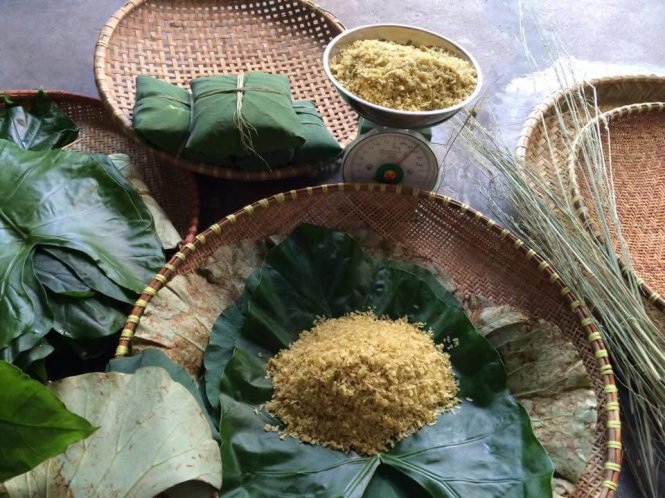Cốm được gói trong hai lớp lá và buộc bằng những sợi rơm vàng - Ảnh: Huyền Trần