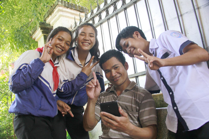 Nụ cười tươi rói của các học trò được nhận nuôi bên sĩ quan biên phòng đồn Lệ Thanh - Ảnh: B.D.