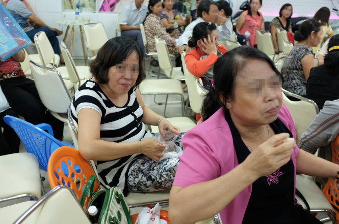 Hai nhà đầu tư ở Vũng Tàu chờ đợi tại Công ty TNHH sản xuất thương mại Kim Mỹ (quận Tân Bình) mong lấy lại được tiền - Ảnh: Hoài Linh