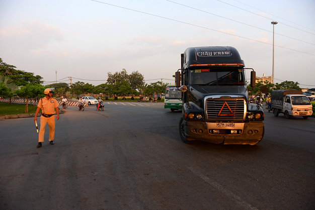 Cảnh sát giao thông điều tiết xe có trọng tải trên 5 tấn không được lưu thông vào quốc lộ 1 bắt đầu từ nút giao Bình Thuận (vòng xoay cầu vượt Nguyễn Văn Linh). Ảnh: Hữu Khoa