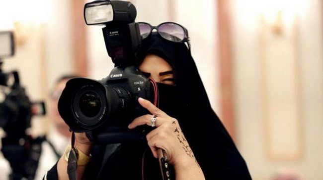Việc phụ nữ được ra ứng cử và đi bầu là bước tiến lớn tại Saudi Arabia - nơi phụ nữ vẫn phải trùm kín người khi đi ra ngoài và không được lái xe. Trong ảnh: một nữ phóng viên đang tác nghiệp ở Riyadh, Saudi Arabia trong trang phục kín từ đầu tới chân - Ảnh: AP