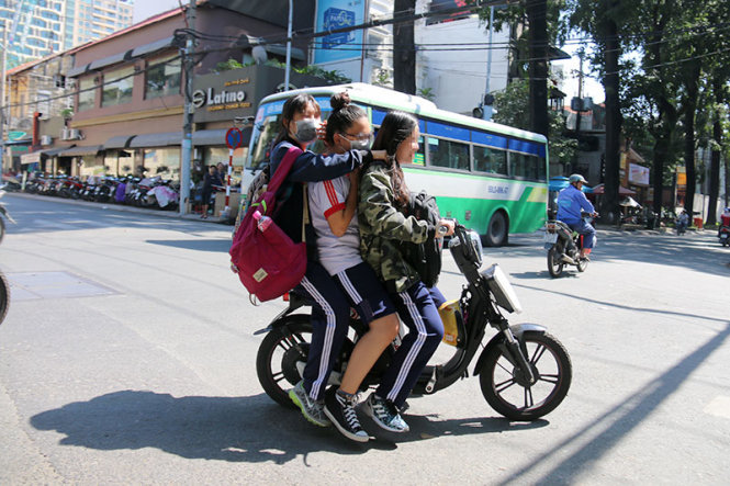 Ba học sinh không đội mũ bảo hiểm chạy xe đạp điện trên đường Ngô Thời Nhiệm (Q.3, TP.HCM) - 
Ảnh: Ngọc Hiển