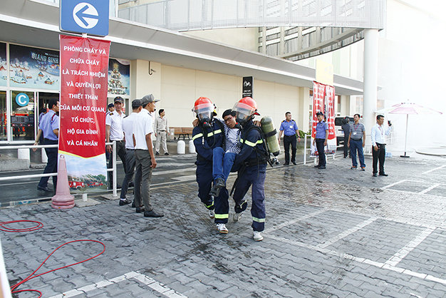 Lính cứu hỏa đeo mặt nạ chống độc đưa nạn nhân ra ngoài an toàn - Ảnh: Xuân An