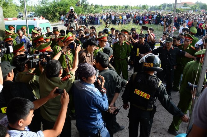 Nguyễn Hải Dương trong vòng vây các cảnh sát tại phiên tòa - Ảnh: Thuận Thắng