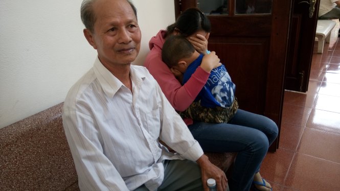 Cha ông Minh buồn rầu còn vợ, con ông Minh ôm nhau khóc sau khi ông Minh bị kết án 7 năm tù - Ảnh: Đức Tuyên