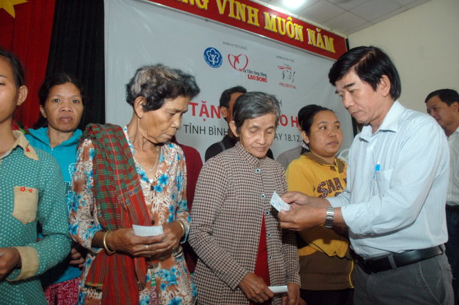 Ông Trần Lý Tâm, Giám đốc BHXH Huyện Lộc Ninh, trao thẻ BHYT cho người dân