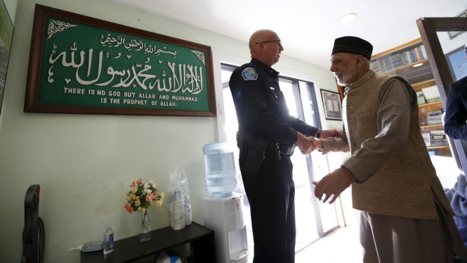 Cảnh sát ở bang California đến bảo vệ ở một đền thời Hồi giáo tại Mỹ trong sự kiện mời công chúng vào xem cách cầu nguyện chiều 18-12 - Ảnh: Reuters