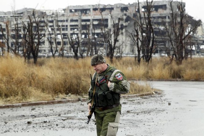 Một thành viên của Cộng hòa nhân dân Donetsk đi dọc con đường hoang tàn ở gần sân bay Donetsk - Ảnh: Reuters