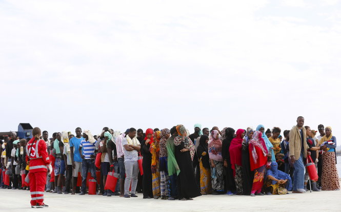 Người di cư và tị nạn chờ cập cảng Augusta ở Ý - Ảnh: Reuters