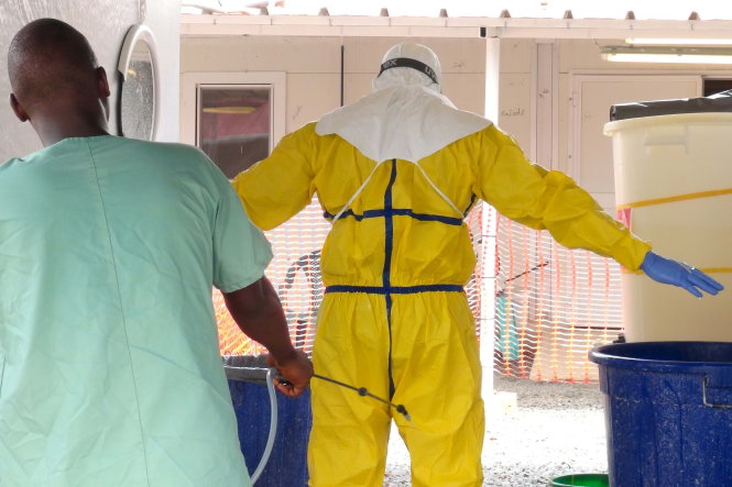 Nhân viên một trung tâm y tế chăm sóc bệnh nhân Ebola ở Guinea được khử trùng - Ảnh: Reuters