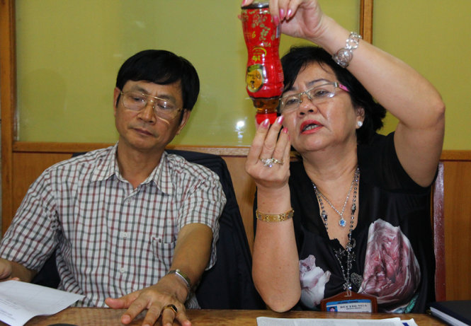 Cán bộ Sở Công thương TP Cần Thơ kiểm tra tình trạng lợn cợn trong chai trà thảo mộc Dr.Thanh mà anh Ngoan cung cấp - Ảnh: Chí Quốc
