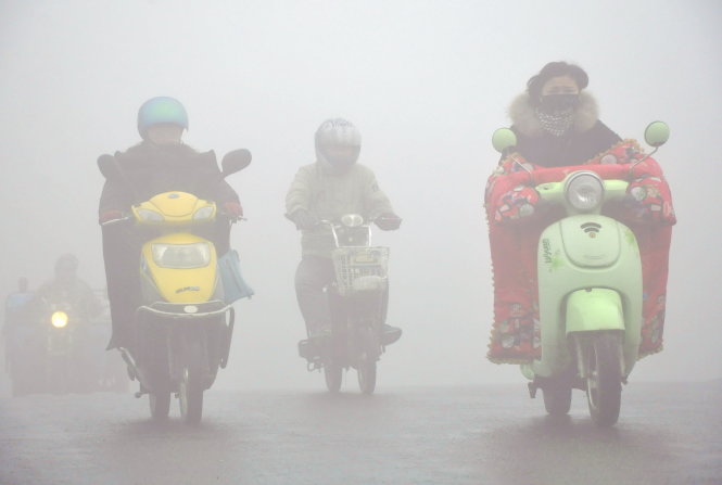 Người dân Dương Châu đi lại trong  bầu không khí ô nhiễm - Ảnh: Reuters