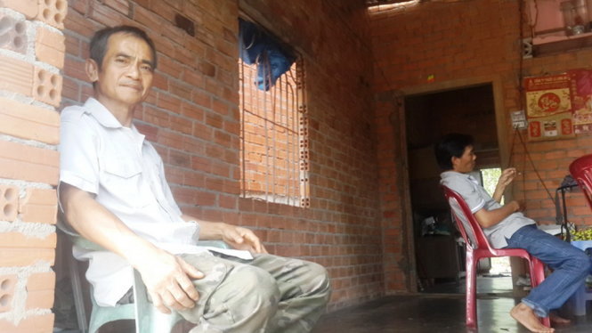 Ông Huỳnh Văn Nén với căn nhà chưa được tô tường của gia đình mình. Ông Nén nói ông muốn sửa sang lại ngôi nhà vì mưa bị tạt nước, còn trời nắng thì nóng hầm hập trên mái tôn phả xuống - Ảnh: NGUYỄN NAM