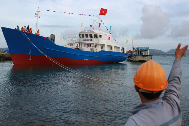 Các công nhân tiến hành hạ thủy tàu vỏ thép dịch vụ hậu cần nghề cá Hoàng Sa chiều 26-12. Ảnh: TIẾN THÀNH