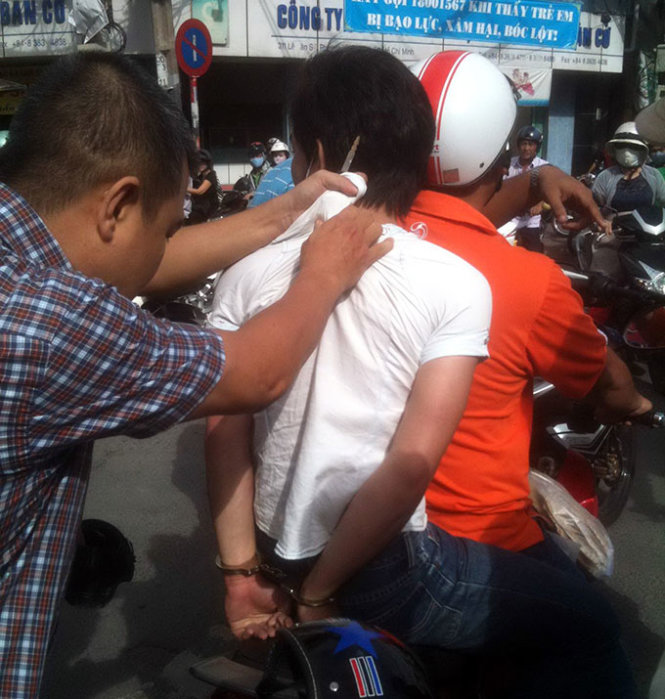 Người dân và đội phòng chống cướp giật bắt một thanh niên giật đồ tại ngã tư Lê Văn Sỹ - Trần Quang Diệu (Q.3, TP.HCM) - Ảnh: Hoàng Kiên