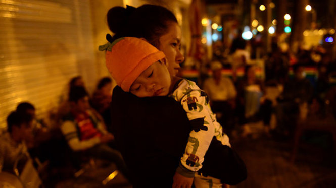 Một em bé cùng mẹ xếp hàng - Ảnh: Quang Định